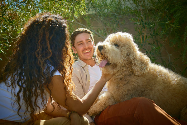 A couple sitting outdoors with their dog